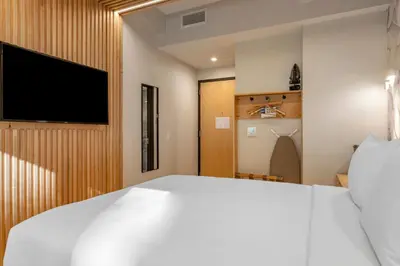 a bedroom with a white bed and a flat screen tv at Best Western Plus Soho Hotel in New York