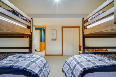a bedroom with two bunk beds and a hallway at Spacious Dover Refuge about 5 Mi to Mount Snow! in Dover