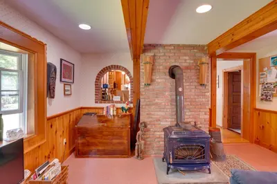 a living room with a brick fireplace and a stove at Waterfalls and Trails at The Mills At Green Hole in Hillsdale