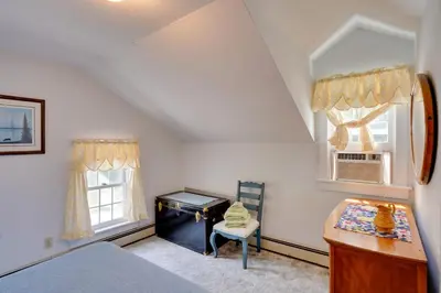 a bedroom with a bed and a desk and two windows at Waterfalls and Trails at The Mills At Green Hole in Hillsdale