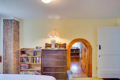 a room with a wooden chest of drawers and a hallway at Waterfalls and Trails at The Mills At Green Hole in Hillsdale