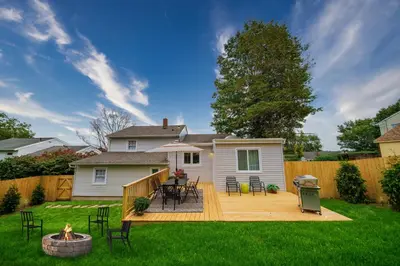 a backyard with a wooden deck with a table and chairs at New Stylish Beach Home near Stamford Downtown/Cove Beach/ 40 min to NYC in Stamford