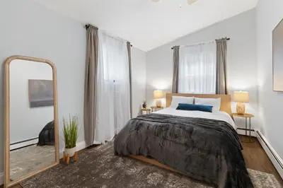 a bedroom with a large bed and a large mirror at New Stylish Beach Home near Stamford Downtown/Cove Beach/ 40 min to NYC in Stamford