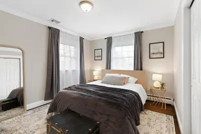 a bedroom with a large bed and two windows at New Stylish Beach Home near Stamford Downtown/Cove Beach/ 40 min to NYC in Stamford