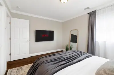 a white bedroom with a bed and a mirror at New Stylish Beach Home near Stamford Downtown/Cove Beach/ 40 min to NYC in Stamford