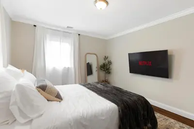 a bedroom with a bed with a tv on the wall at New Stylish Beach Home near Stamford Downtown/Cove Beach/ 40 min to NYC in Stamford