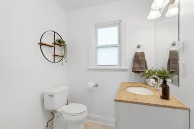 a white bathroom with a toilet and a sink at New Stylish Beach Home near Stamford Downtown/Cove Beach/ 40 min to NYC in Stamford