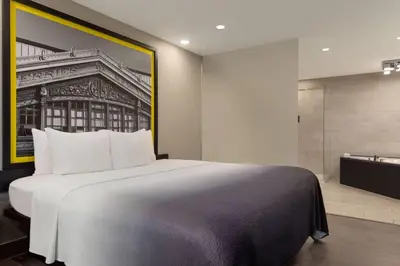 a bedroom with a large bed and a bathroom at Super 8 by Wyndham Meadowlands in Carlstadt