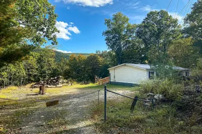 a house on the side of a road with a fence at Port Jervis Home about 8 Acres with Mountain View! in Port Jervis