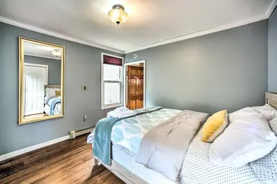 a bedroom with a large bed and a mirror at Pet-Friendly Latham Retreat about 7 Mi to Albany! in Latham