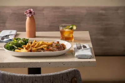 a plate of food and french fries on a table at Hotel Marcel New Haven, Tapestry Collection By Hilton in New Haven