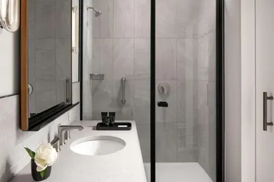 a white bathroom with a sink and a shower at Hotel Marcel New Haven, Tapestry Collection By Hilton in New Haven