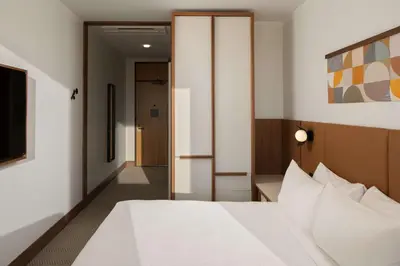 a bedroom with a white bed and a hallway at Hotel Marcel New Haven, Tapestry Collection By Hilton in New Haven