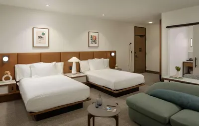 a hotel room with two beds and a couch at Hotel Marcel New Haven, Tapestry Collection By Hilton in New Haven