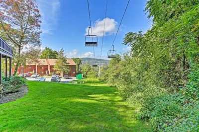 a green yard with two chairs on a cable car at Vernon Condo with Deck, Near Appalachian Trail! in Vernon Township