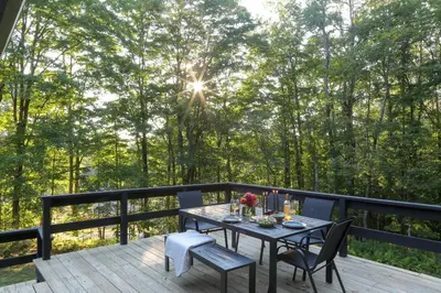 a wooden deck with a table and chairs on it at Modern Hideaway with Deck and State Forest Access in Livingston Manor