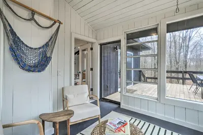 a room with a chair and a window at Modern Hideaway with Deck and State Forest Access in Livingston Manor