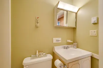 a bathroom with a sink and a toilet and a mirror at Dover Condo with Grill and Balcony 3 Mi to Mt Snow! in Dover
