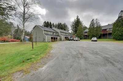 a large house with cars parked in the driveway at Dover Condo with Grill and Balcony 3 Mi to Mt Snow! in Dover