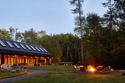 a building with a group of chairs and a fire at AutoCamp Catskills in Saugerties
