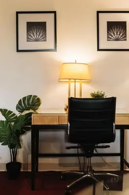 an office with a desk and a chair and a lamp at Stamford Suites in Stamford