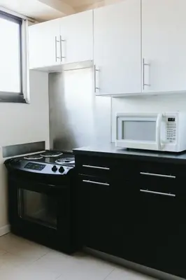a kitchen with a stove and a microwave at Stamford Suites in Stamford