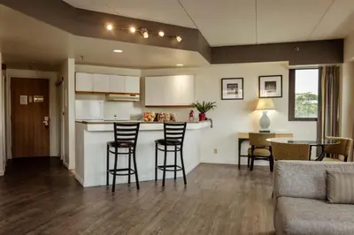 a kitchen and living room with a bar and chairs at Stamford Suites in Stamford