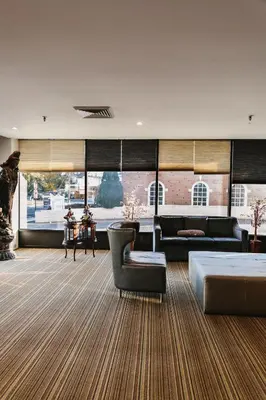 a living room with a couch and a chair at Stamford Suites in Stamford