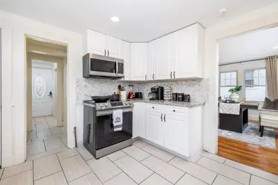 a kitchen with white cabinets and a stove top oven at Gorgeous 3 bedroom - 9 mins to Hartford, Connecticut in West Hartford