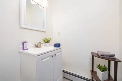 a white bathroom with a sink and a mirror at Gorgeous 3 bedroom - 9 mins to Hartford, Connecticut in West Hartford