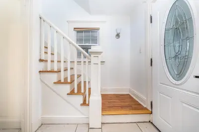 a white hallway with a white door and stairs at Gorgeous 3 bedroom - 9 mins to Hartford, Connecticut in West Hartford