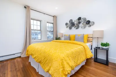 a bedroom with a yellow bed with a yellow comforter at Gorgeous 3 bedroom - 9 mins to Hartford, Connecticut in West Hartford