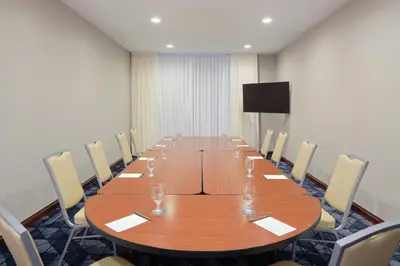 a conference room with a long wooden table and chairs at Courtyard by Marriott Saratoga Springs in Saratoga Springs