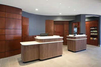 a lobby with wooden cabinets and a reception counter at Courtyard by Marriott Saratoga Springs in Saratoga Springs