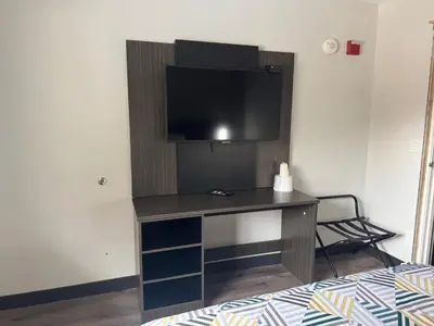 a room with a desk with a television on a wall at Motel 6-Enfield, CT - Hartford in Enfield