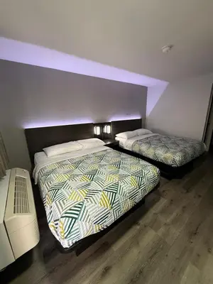 two beds in a hotel room with purple lighting at Motel 6-Enfield, CT - Hartford in Enfield