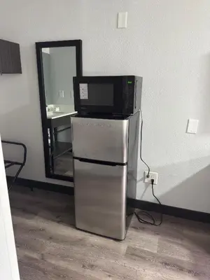 a microwave sitting on top of a refrigerator in a room at Motel 6-Enfield, CT - Hartford in Enfield