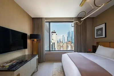 a hotel room with a bed and a large window at The Ritz-Carlton New York, NoMad in New York