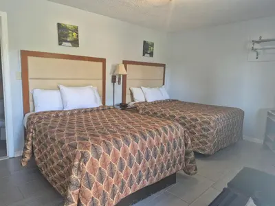 two beds in a hotel room with two beds at Maple leaf motel in New Milford