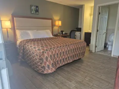 a hotel room with a bed and a bathroom at Maple leaf motel in New Milford