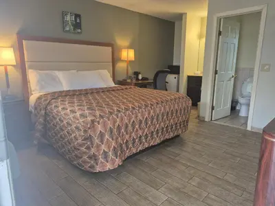 a hotel room with a bed and a bathroom at Maple leaf motel in New Milford