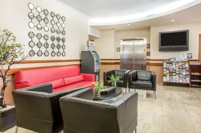 a waiting room with a red couch and chairs at Econo Lodge in West Haven