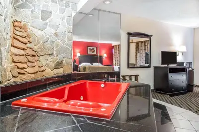 a red bath tub in a room with a bedroom at Econo Lodge in West Haven