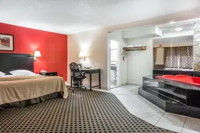 a hotel room with a bed and a bath tub at Econo Lodge in West Haven