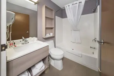 a bathroom with a sink and a toilet and a tub at Microtel Inn & Suites by Wyndham Bethel/Danbury in Bethel