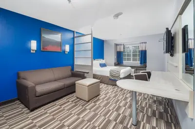 a living room with a couch and a bed at Microtel Inn & Suites by Wyndham Bethel/Danbury in Bethel