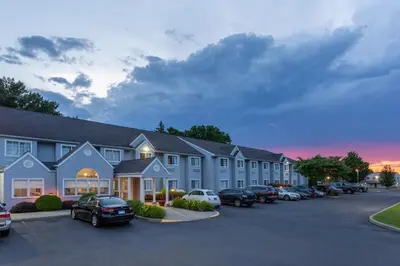 a large building with cars parked in a parking lot at Microtel Inn & Suites by Wyndham Bethel/Danbury in Bethel