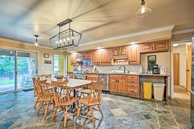 a large kitchen with a table and chairs in it at Family Winter Retreat with Hot Tub 14 Mi to Slopes! in Whitingham
