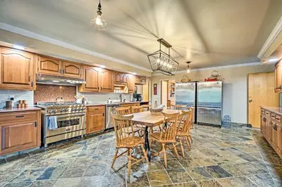 a large kitchen with a wooden table and chairs at Family Winter Retreat with Hot Tub 14 Mi to Slopes! in Whitingham
