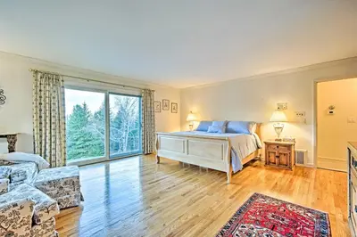 a bedroom with a bed and a large window at Family Winter Retreat with Hot Tub 14 Mi to Slopes! in Whitingham